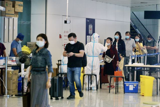 到达旅客进行免费落地核酸检测机场工作人员全力保障机场正常运行为