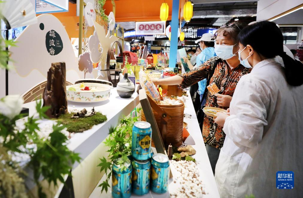 2021年5月29日，参观者在一家豫园老字号饭店展台前挑选商品。当日，全国消费促进月“老字号嘉年华”及第十五届中华老字号博览会在上海世博展览馆举行。新华社记者 方喆 摄