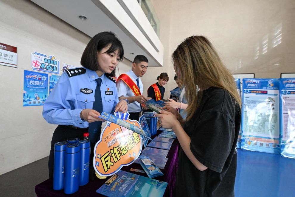 2023年5月23日,民警在天津师范大学指导学生下载反诈App。新华社记者 孙凡越 摄