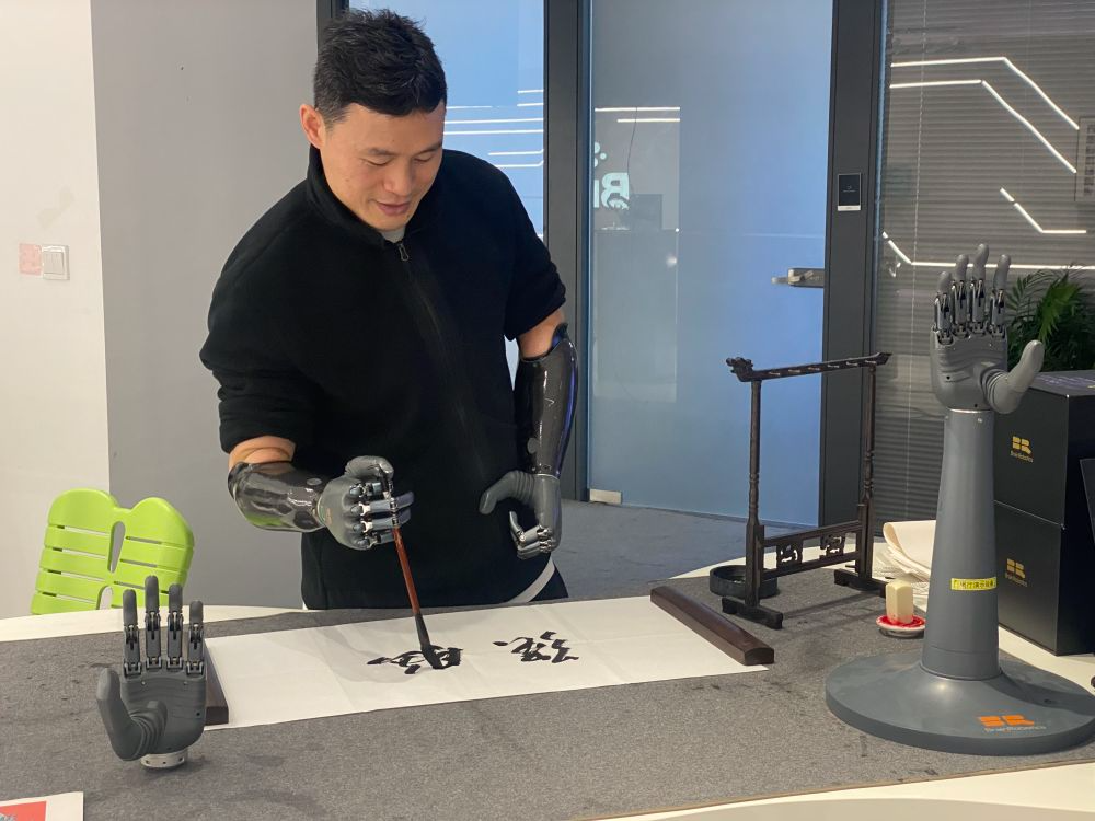 2024年3月29日,在浙江强脑科技有限公司展厅内,失去双手的产品体验官倪敏成依靠智能仿生手写毛笔字。新华社记者 魏一骏 摄