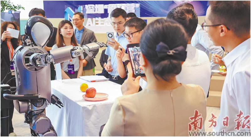 现场展出一批AI创新应用成果,图为优必选人形机器人Walker表演抓取橙子,吸引观众围观。受访者供图