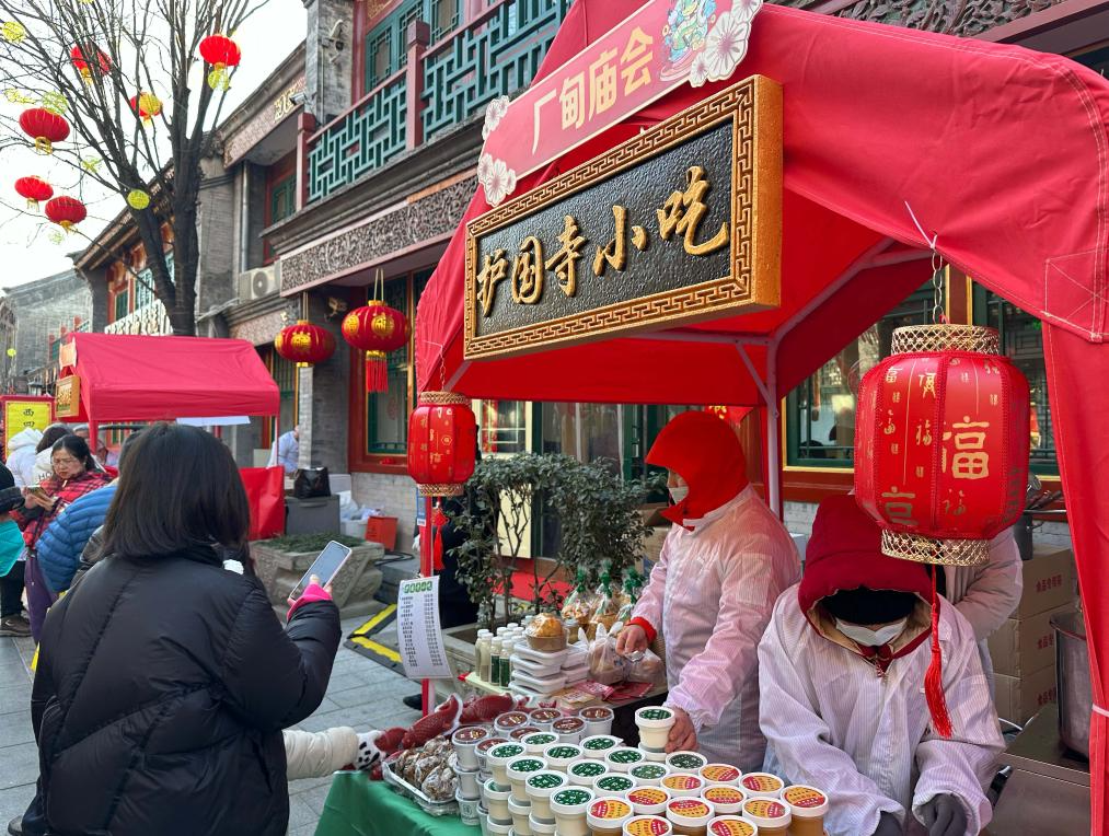 1月29日，游客在北京厂甸庙会购买特色小吃。新华社记者 杨淑君 摄