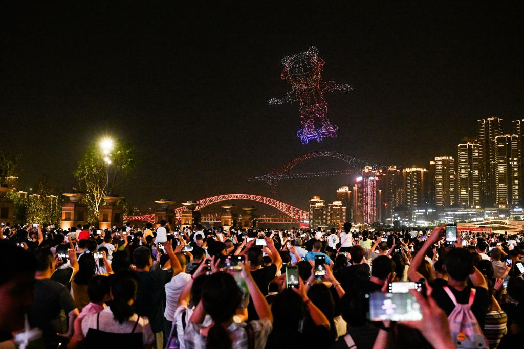 5月2日晚，游客在重庆朝天门广场观看无人机灯光秀。新华社记者 王全超 摄