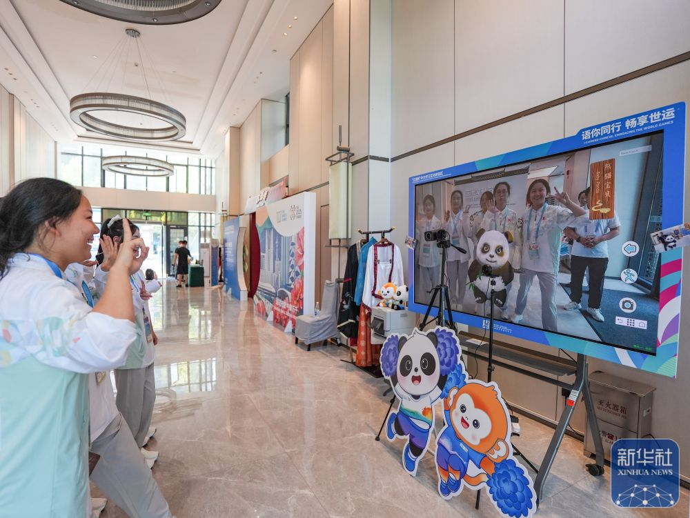 在成都世运会运动员村A区中文学习互动体验区，志愿者在测试自拍互动相机。新华社记者 王曦 摄