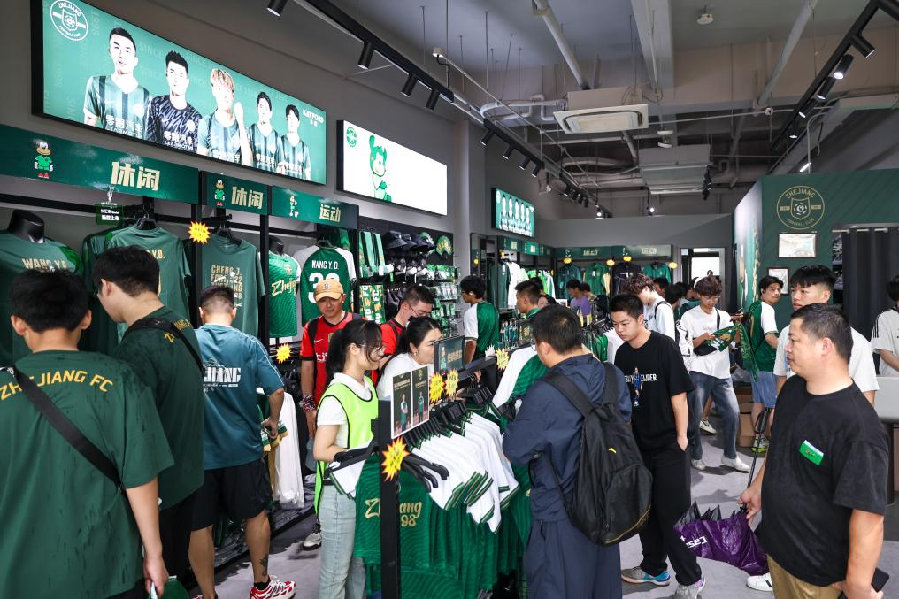 6月14日，在中超联赛浙江俱乐部绿城队对阵上海海港队的比赛前，球迷在浙江俱乐部官方商店内购物。新华社记者 江汉 摄