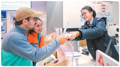 外籍旅客在云南香格里拉站“香巴拉·金花”服務(wù)臺購票。楊紫軒攝（新華社發(fā)）