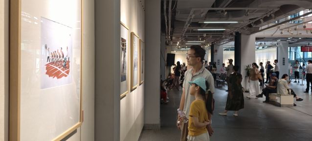 虎逊小学的学生肖绮婷听爸爸讲解漫画作品寓意。林燕英摄.jpg