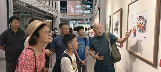 广东省第三届漫画作品展暨“廉洁文化”漫画作品展现场,漫画作品创作者之一邝先生为市民导赏漫画。林燕英