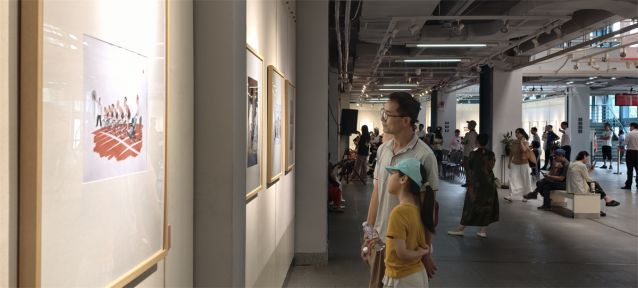 虎逊小学的学生肖绮婷听爸爸讲解漫画作品寓意。林燕英摄.jpg