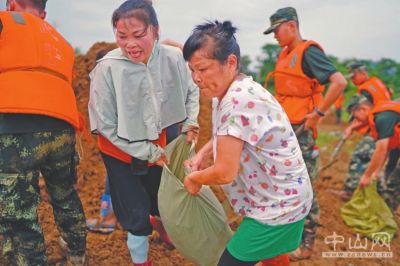 7月11日,在鄱阳镇江家岭村"阿姨团"成员江云风(前)和余风英在圩堤