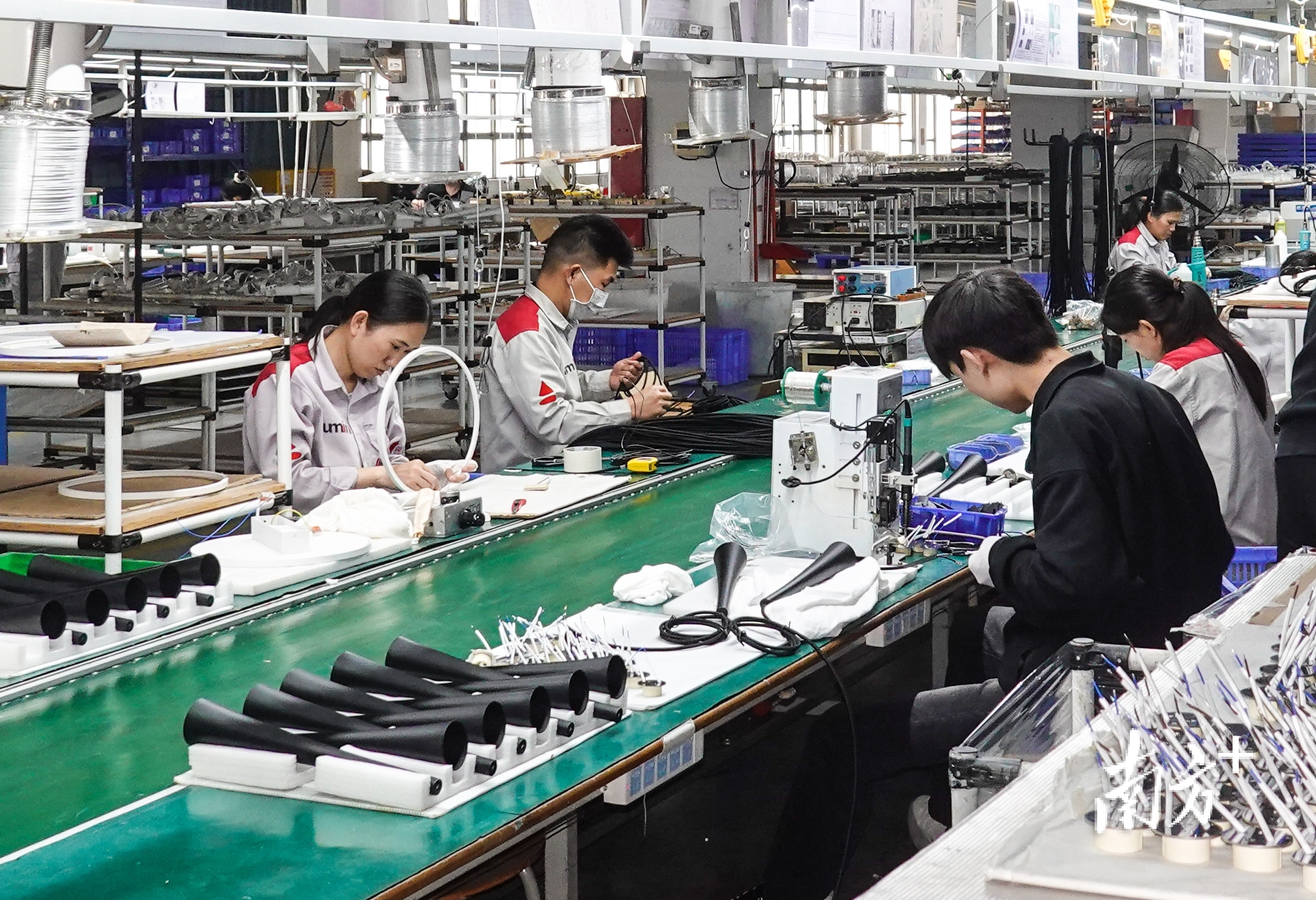 在中山市阿鲁米尼照明有限公司车间内，工人正在进行装配作业。