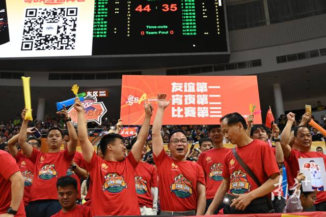 河源球迷高舉“友誼第一、宵夜第二、比賽第三”標語。