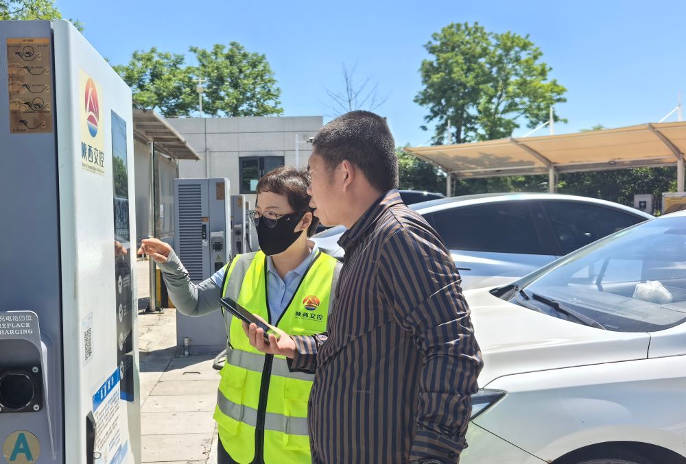 5月3日,陕西澄城服务区工作人员协助新能源汽车车主充电。新华社发