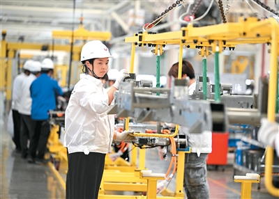 7月30日，位于广西壮族自治区柳州市的一家车企新能源汽车基地内，工人在生产无人驾驶物流车。