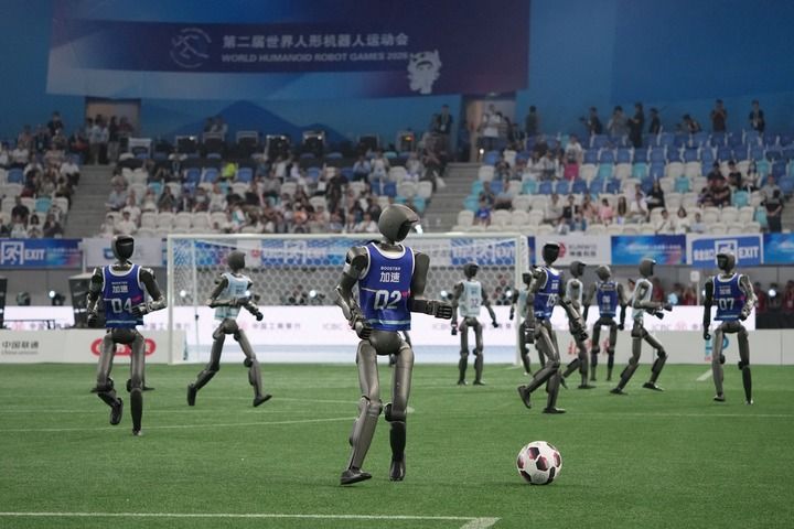 在第二届世界人形机器人运动会上,机器人在进行足球7V7表演赛(2026年8月22日摄)。新华社记者 鞠焕宗 摄